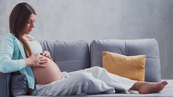 Young pregnant woman is resting at home and expecting a baby.