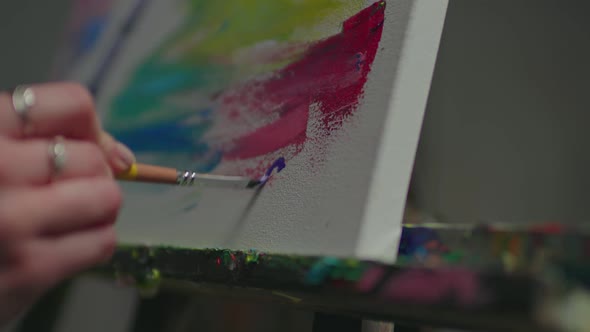 Closeup of Female Artist Putting Signature on Painting