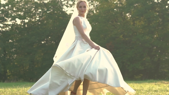 Pretty Bride In White Dress Spinning In The Field. Slowly