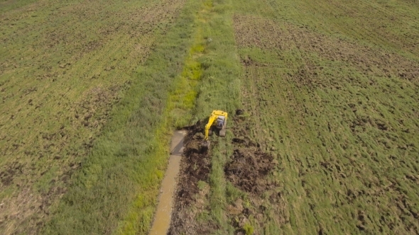 Excavator Digging a Trench In The field.Aerial Video.