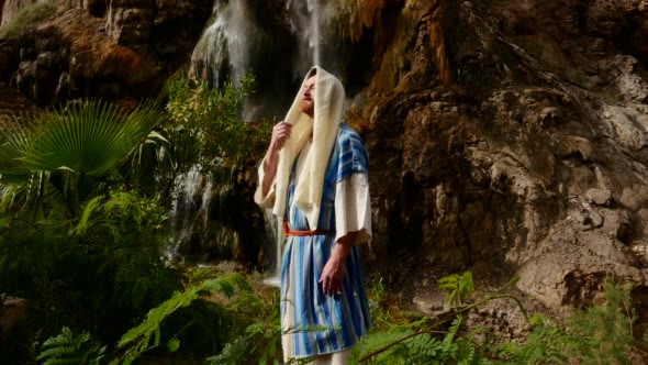 Man Near a Waterfall and Fern