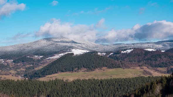 Epic misty clouds moving over snowy mountains in winter nature landscape