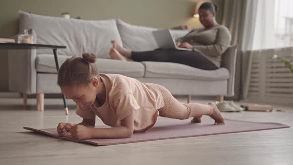 Little Girl Doing Plank Exercise at Home