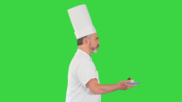 Male Pastry Chef Walking Fast with Dessert in His Hands on a Green Screen Chroma Key