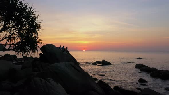 Silhouette Tourists Are Sitting On The Big Rock.