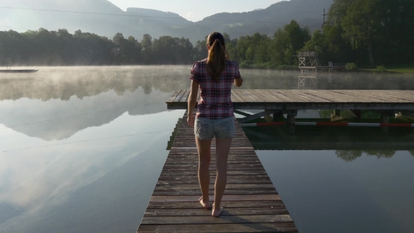 Woman Calling On The Mobile Phone Walking On Dock