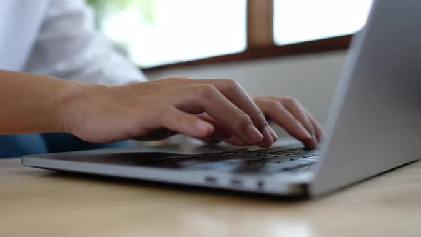 Closeup a woman working and typing on laptop computer keyboard on the table