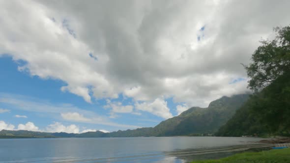 Timelapse of Wonderful Landscape with Lake and Green Mountains and White Clouds Floating Rapidly