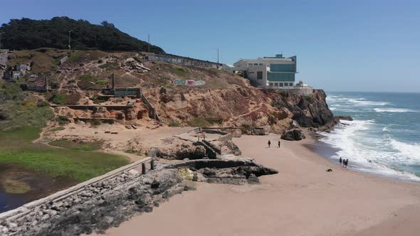 Aerial rising push-in shot of the Cliff House next to the ruins of the Sutro Baths at Land's End, Sa