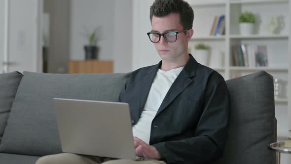 Young Male Designer Working on Laptop at Home