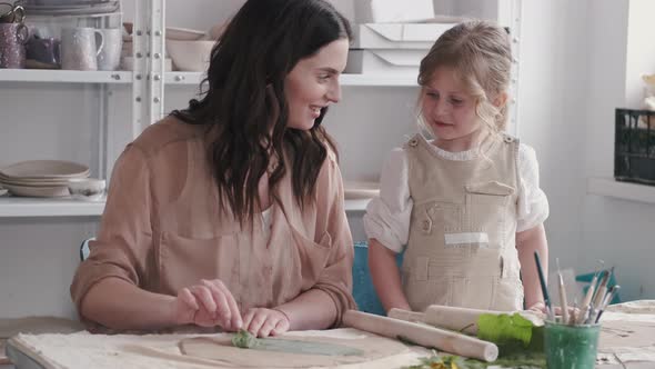 Portrait of Mother and Little Girl Shaping Clay Together