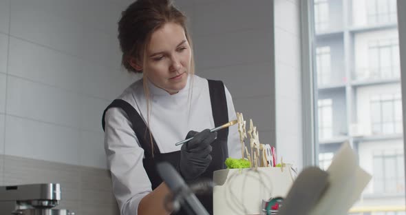 The Confectioner Decorates a Birthday Cake in the Confectionery Shop