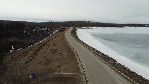 Fly over edge of Brasseau Dam in winter