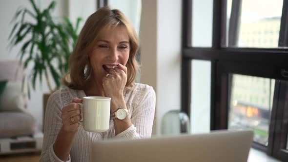 Woman Talking in Front of Laptop Screen and Having Fun at Table in Apartment Room