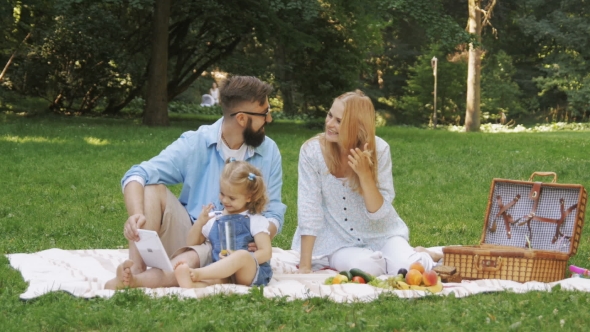 Young Family Having Picnic Outdoors