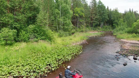 Aerial of Man Driving All-Terrain Vehicle through River