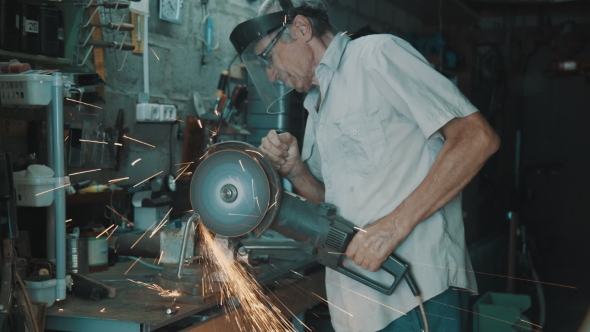 Senior Man Working With Angle Grinder