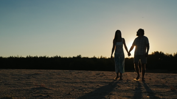 Romantic Young Couple Walking At Sunset