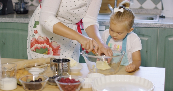 Mother Teaching Her Small Daughter To Bake