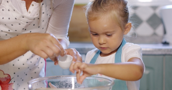 Cute Little Girl Adding Salt To a Baking Mixture