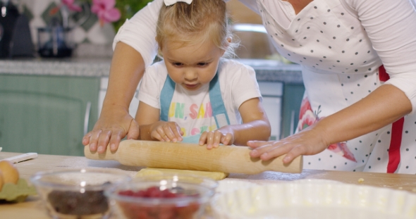 Mother Rolling Out Pastry With a Little Helper