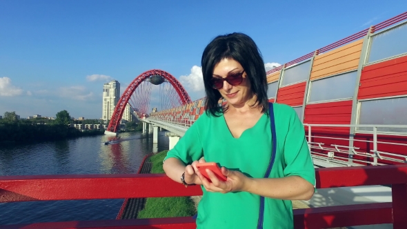 Girl Goes On a Modern Bridge And Talking On Smartphone
