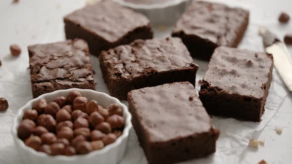 Fresh Homemade Chocolate Brownie Served with Hazelnuts and Melted Cream