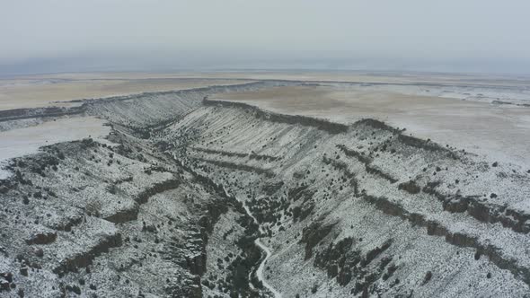 Wide drone panning shot of snowy canyon in Idaho