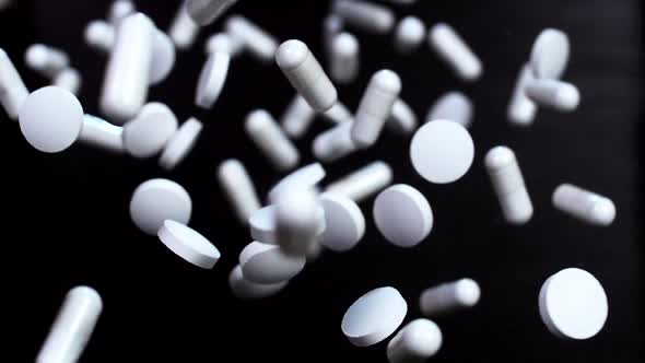 Pharmaceutical drugs on a black background. Super slow motion. Macro
