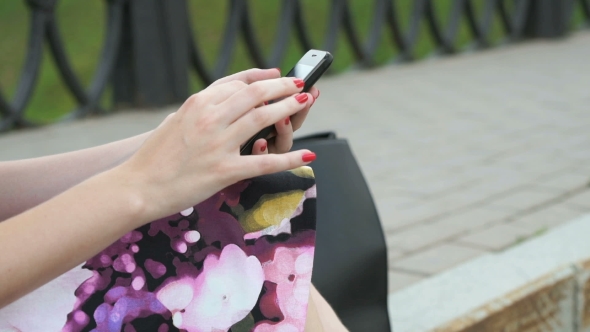 Young Girl Holds a Cellphone And Reads Messages