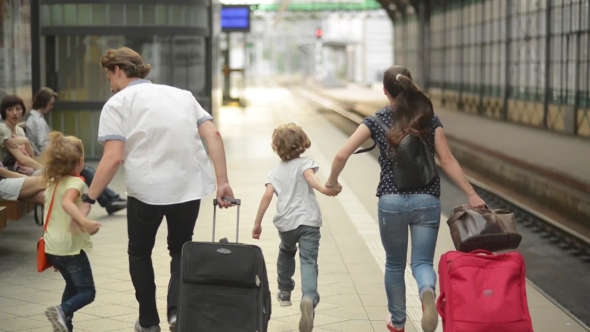 Young Family Of Two Spouses, Son And Daughter, Running In The Railway Station, Father Holding