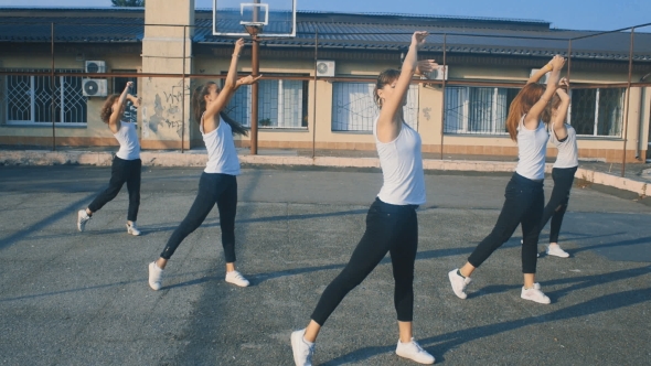 Girls In White T-shirts Dancing On The Playground In 