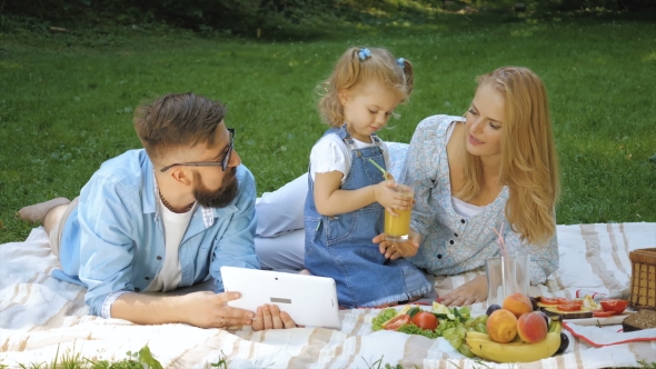 Young Family Having Picnic Outdoors