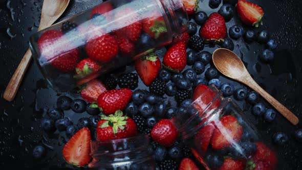 Cooking Raspberry and Blueberry Berry Jam. Place in a Glass Jar.. Rotation on a Black Background