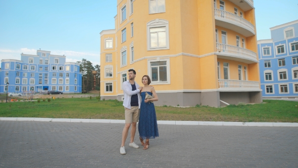 Man And Woman Strolling Along The Fashionable Residential Area.
