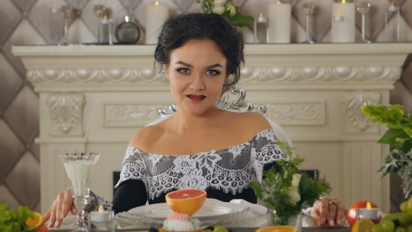 Brunette Lady Model at a Table With Fruits Posing on Camera