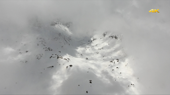 Aerial Snowy Mountains Through the Cloud