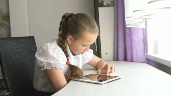 Schoolgirl Uses a Digital Tablet Computer At Home