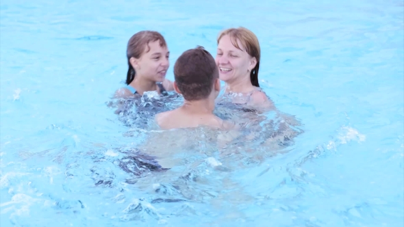 Happy Family Enjoying In Pool