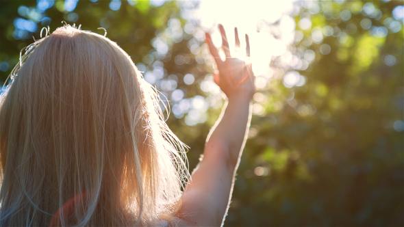 Beautiful Blonde Girl Playing with the Sun in City Park 1