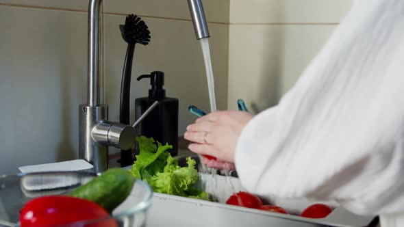 Unrecognizable Woman Washing Tomato in Kitchen Sink Indoors