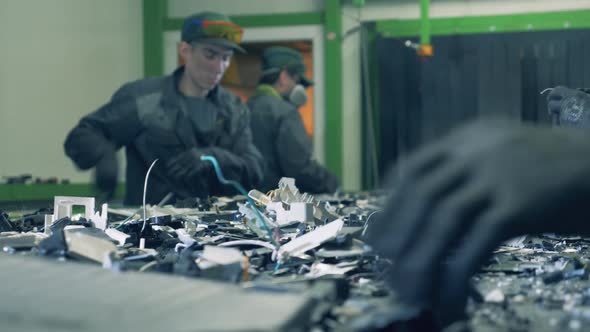 Men in Uniform Sort Rubbish on Moving Conveyor.