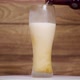 Beer with foam is poured into a frozen glass. Wooden background. - VideoHive Item for Sale