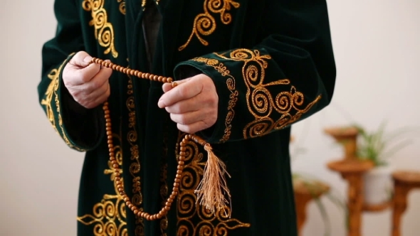 An Old Mullah in National Dress Praying With Rosary Beads in Hands