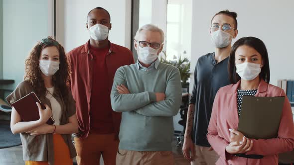 Diverse Business Team in Face Masks Posing for Camera in Office