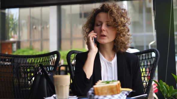 Businesswoman Using Tablet And Smartphone Having Lunch