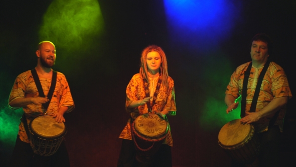 Three Drummers Perform On The Stage