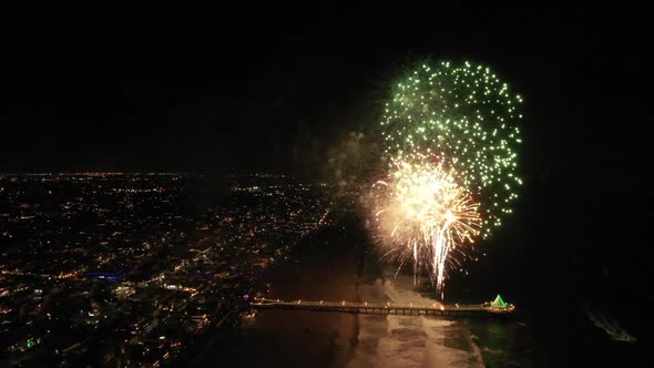 Grand finale of Christmas fireworks show over a beach pier in California, USA.