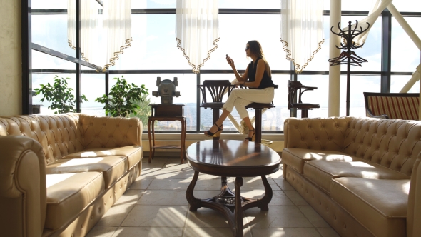 Beautiful Girl Sitting In The Lobby And Uses The Phone