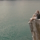 Young Active Backpacker Girl Relaxes By Resting On Mountain Rock Upon Large Water Surface Of - VideoHive Item for Sale